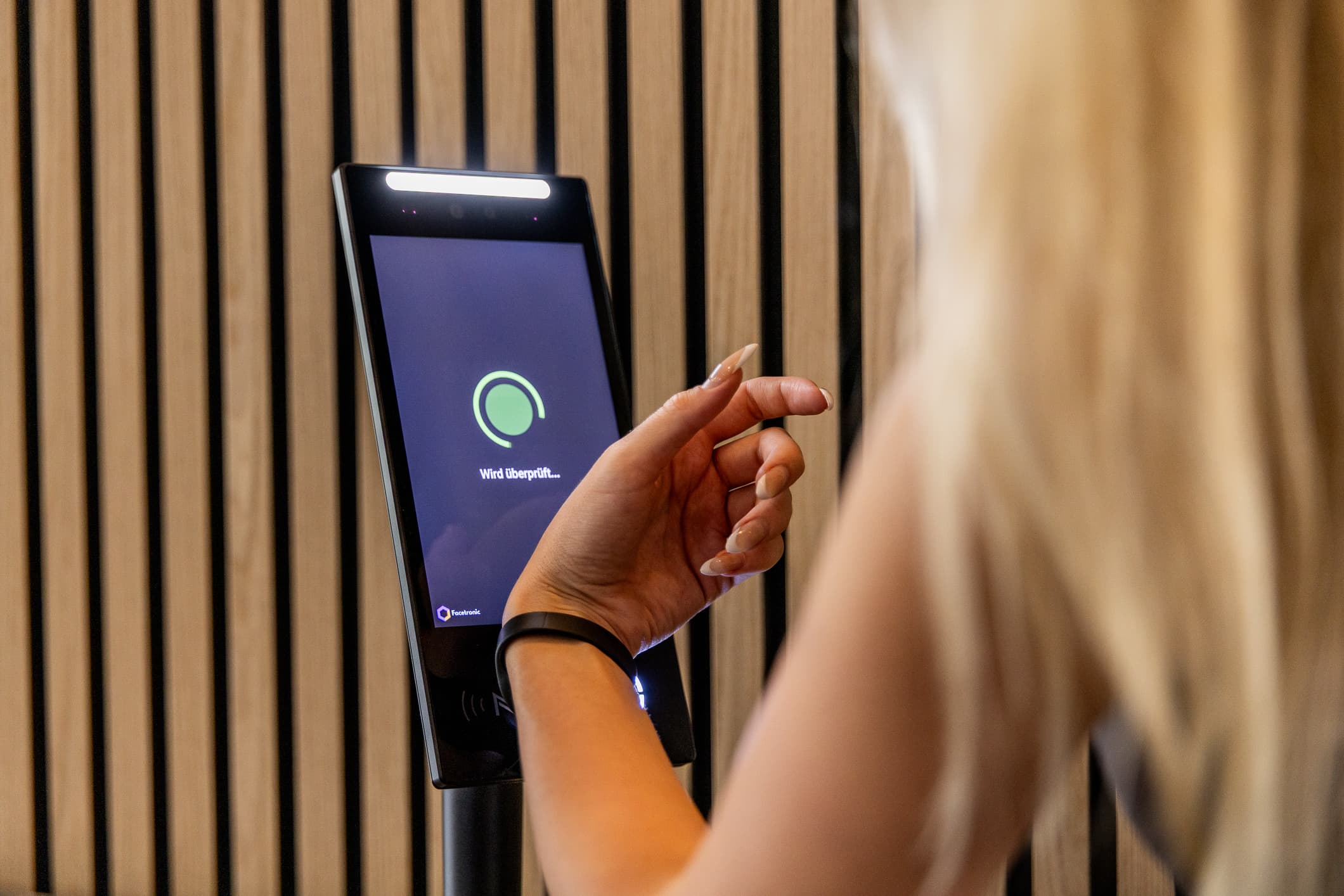 Mitglied hält RFID-Armband an den IDA Leser, Zutritt wird überprüft